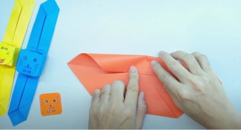 Lật tờ giấy sang mặt kia, xoay theo chiều dọc rồi gập đôi lại